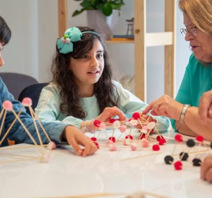 Grandmother playing educational games with grandchildren indoors, fostering creativity and learning.