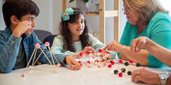 Grandmother playing educational games with grandchildren indoors, fostering creativity and learning.